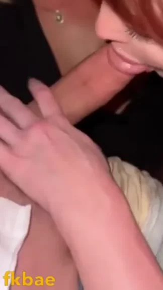 Two girls take turns deep throating one guy cock at dimly lit bar with red lantern overhead